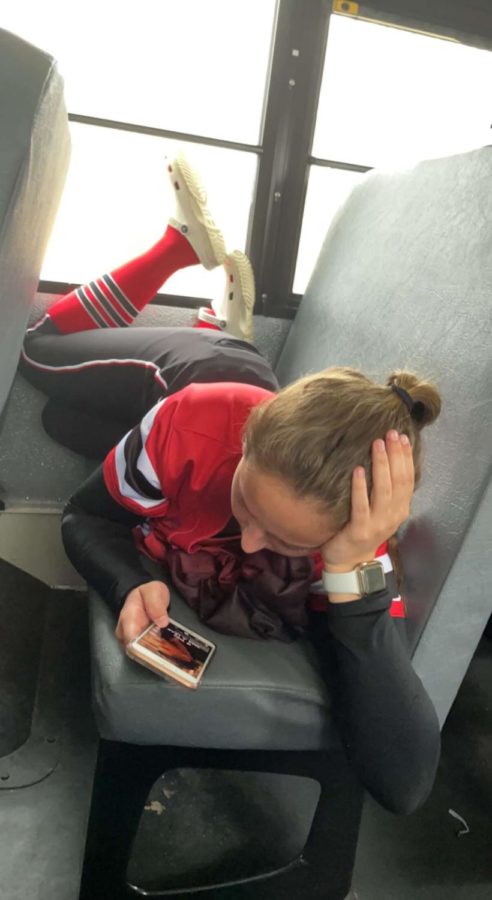 Taelynn Benish laying down watching TikTok on the way to a softball game. sometimes one of the most boring things about sports is getting there with anticipation before a game/meet.