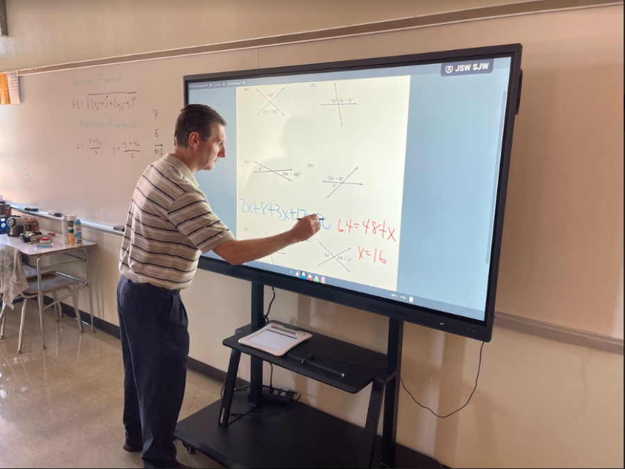 Writing on the Clevertouch board, math teacher Kevin Reed instructs students on  the beginning steps of geometry. The boards seem to work similarly to the previous Epson projectors and Promethean boards.