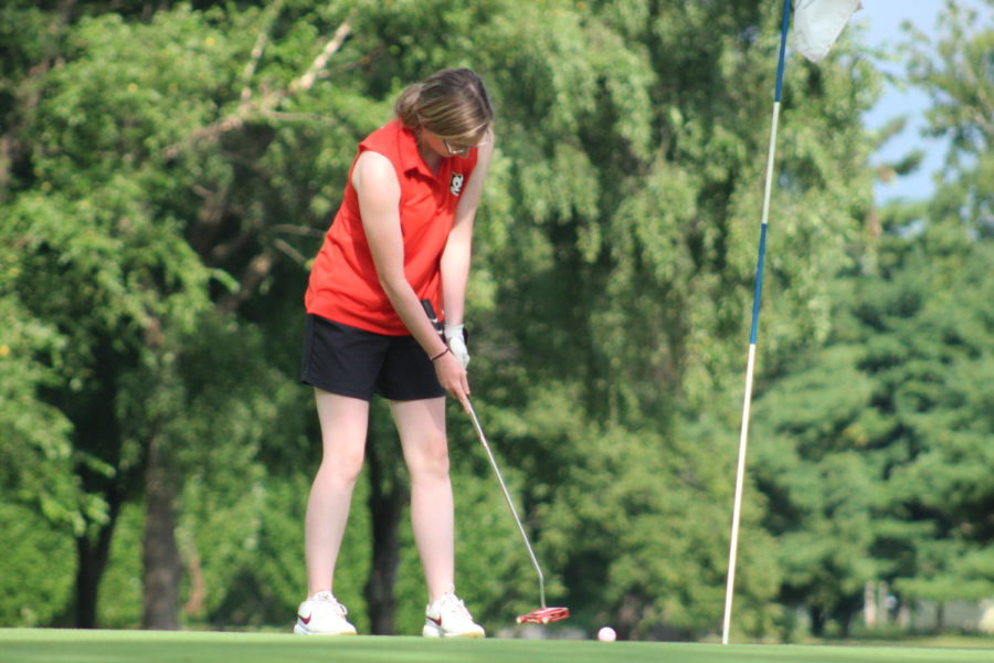 Junior Reiss Weaver eyes the ball, making sure that when she hits it, the ball gets in the hole. 