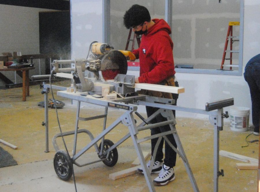 (Above) Junior Alexis Jose cutting wood for the renovation.
