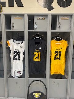 Three Depauw Football jerseys hang from senior Jeremiah Miller’s custom locker. Each jersey is designed with his last name on the back. 