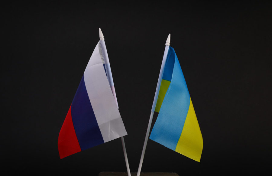 Russia invaded Ukraine on February 24, 2022. The war is ongoing. Flags of the Russia and Ukraine on the black background.