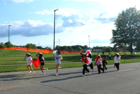 Chinese Club members are running down the street during the Homecoming Parade.