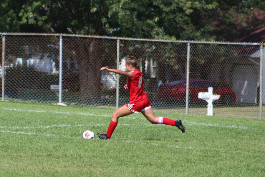 Senior Arlene Frutos kicks the ball as she tries to clear it for her team on defense. 