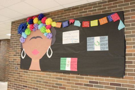 The bulletin board in G-wing displays facts about Hispanic culture with artwork representing Frida Kahlo. 
