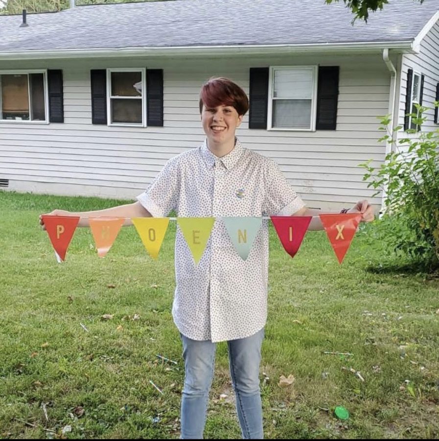 Sophomore Phoenix Cripe displays flags spelling out his name from his gender/name reveal party.