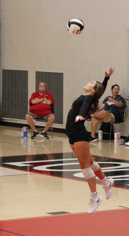 Jumping up in the air, senior Chloe Kelly serves the ball over to Knox. 