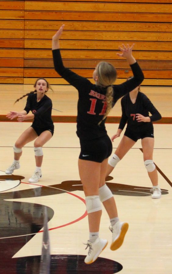 Leaping out of her shoes, senior Finley Hettinger gets ready to spike the ball  on the Warriors. 