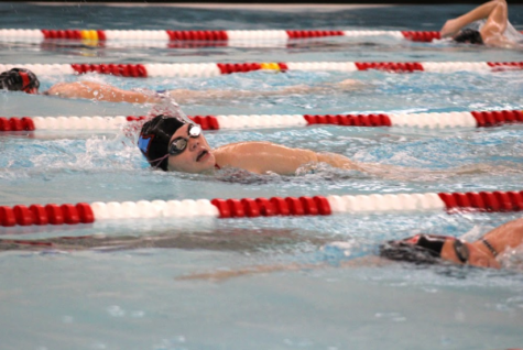 Coming up for a breath, senior Atticus Picardo swims the catch up drill to help better his stroke.