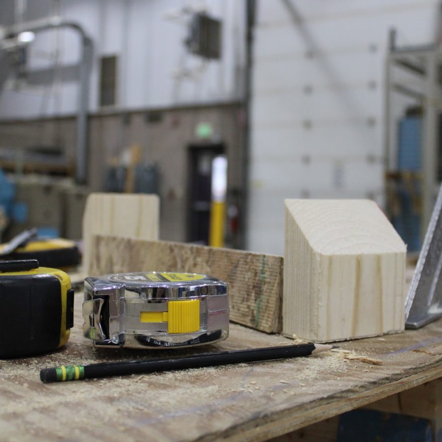 An assortment of tools used by the Building Trades students, including measuring tape, pencils, and a set square (the triangle ruler).