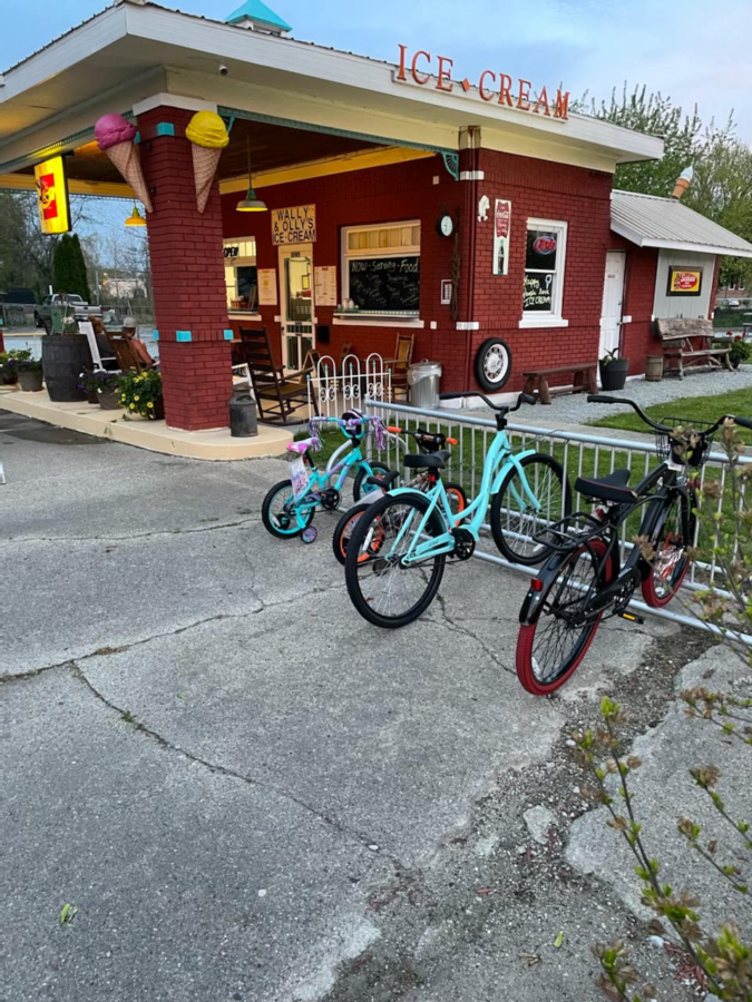 The front of Wally and Ollys is decorated by a variety of items, like bikes, rocking chairs, and flowers.