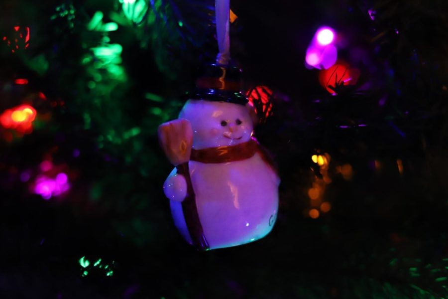  A snowman ornament hangs from a branch on a colorful Christmas tree. According to oldworldchristmas.com, the tradition of decorating Christmas trees was intended to remember the birth of Jesus. Originally, trees were decorated with religious ornaments to honor the true meaning of Christmas. 
