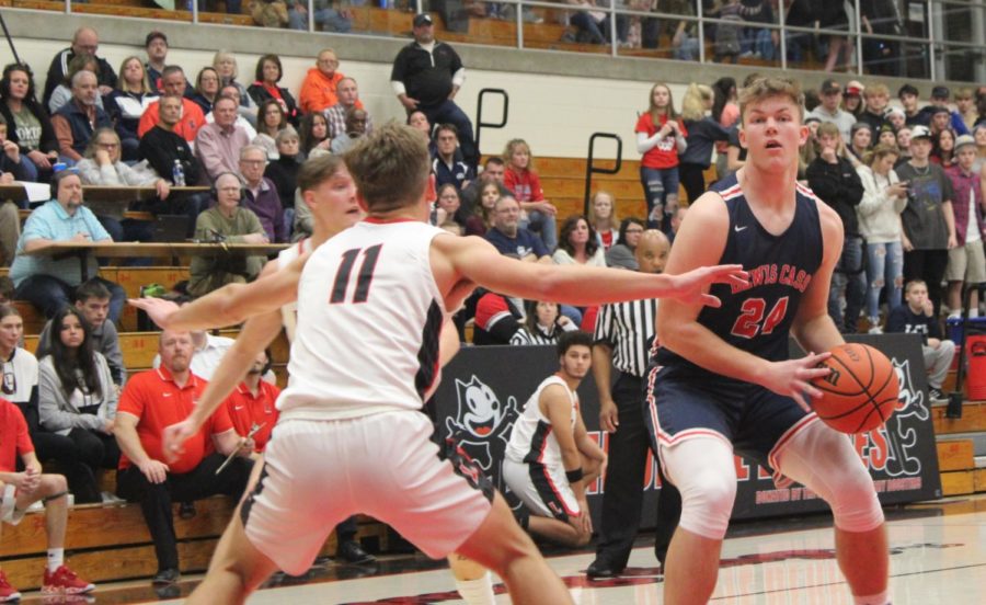Guarding a Lewis Cass player, senior Izak Mock attempts to stop the Kings from scoring.