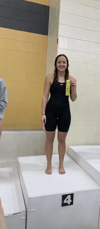 Logansport senior Taelynn Benish poses with her fourth place ribbon on the podum inside the Boilermaker Aquatic Center on Saturday, Jan. 7.