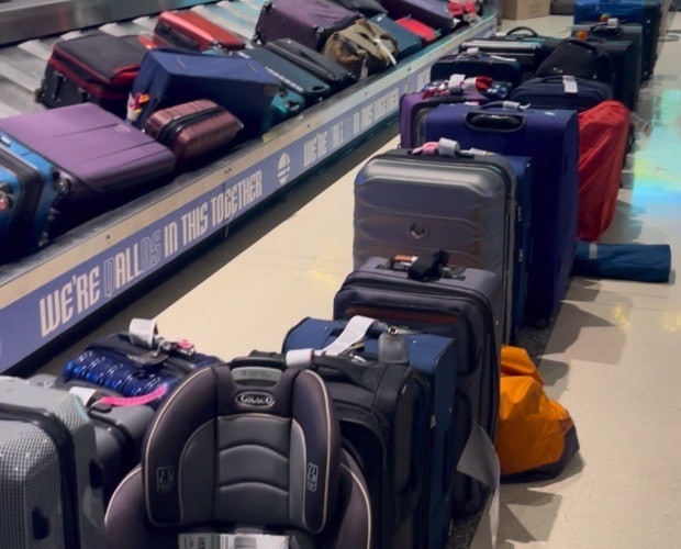 At Dallas Love Field Airport, customers baggage from cancelled flights wait for their owners. Some of the baggage was from customers who were still stuck in another city. Baggage was storied all over the baggage claim, even piled up to the ceiling.