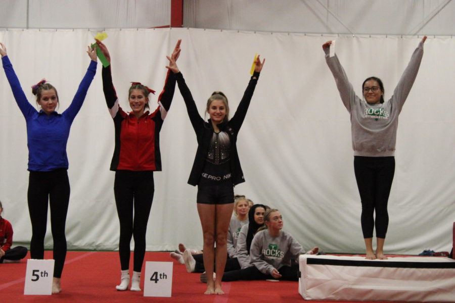 Standing among other participants, freshman Rylee Zimmerman celebrates a fourth place finish in the vault at a Jan. 23 home meet. Zimmerman was also able to finish first in all-around, bars and beam.