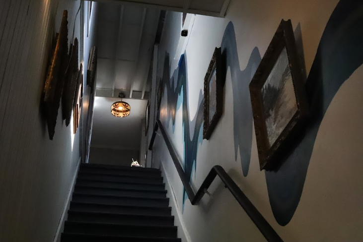Paintings line the walls of the stairway to the upstairs of Black Dog. The upstairs is named Black Dog Studios and has spaces open for small businesses to operate out of. 