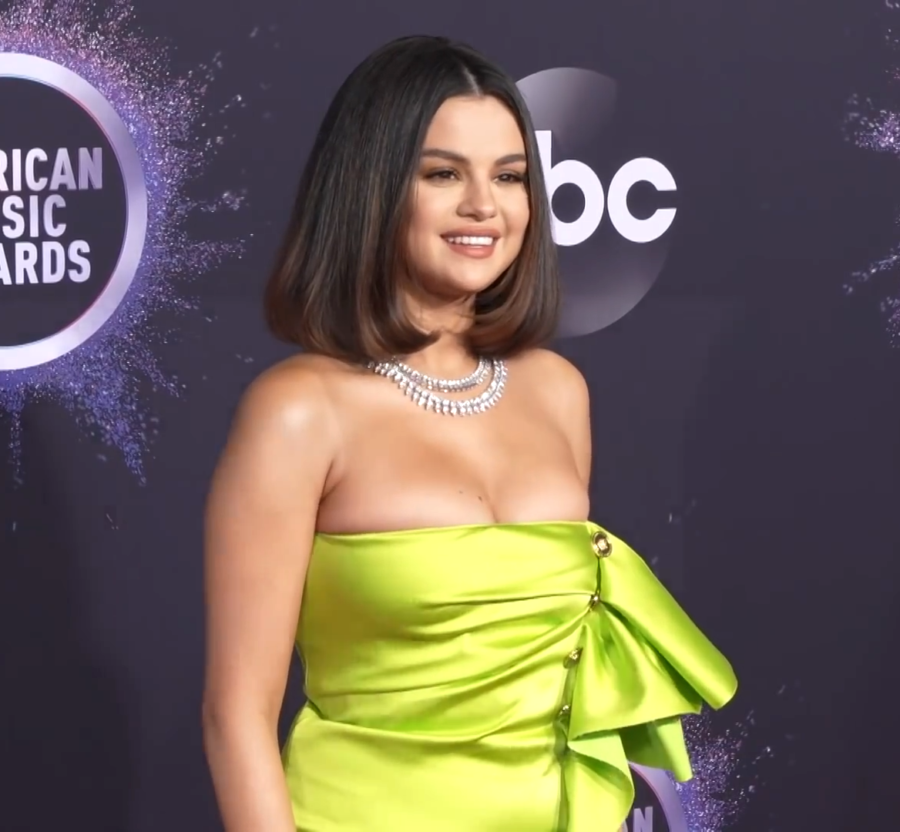 Selena Gomez wears a lime green dress as she walks the carpet at the American Music Awards. Gomez is an American singer, actress, producer, and businesswoman. She’s spent most of her acting career working with Disney Channel. As she got older, she started to pursue music. As of February 2023, Gomez has won 150 awards and got 455 nominations. One of her newer accomplishments was founding the makeup brand, Rare Beauty. 