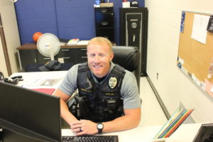 Sitting at his desk, Sgt. Travis Nolte gives a smile. Having a smile is key to his job at a school to always be approachable.