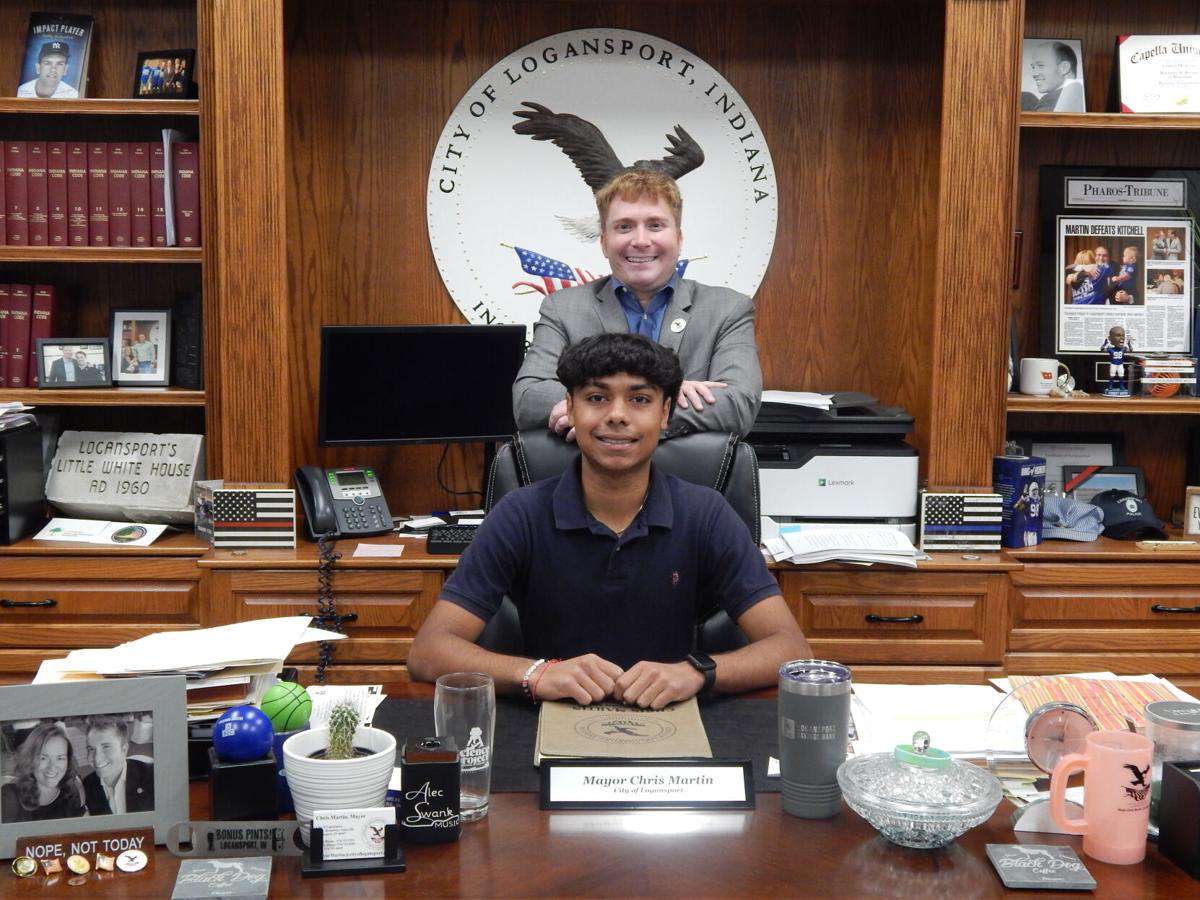 Sitting at Logansport Mayor Chris Martins desk while Martin stands behind him, Patel and Martin pose for a picture. Patel became Martins intern at the beginning of the school year. 