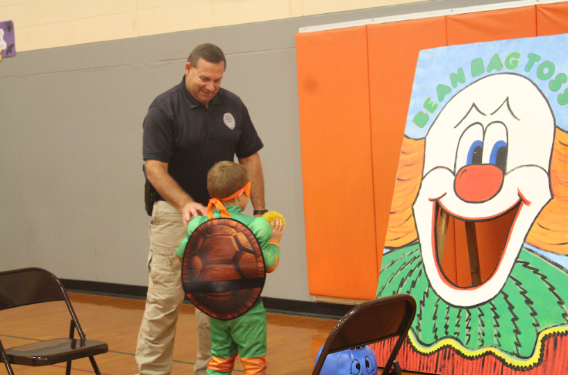 Helping a student with the game is officer Danny Farris. The student attempted to throw a ball into the clowns mouth.