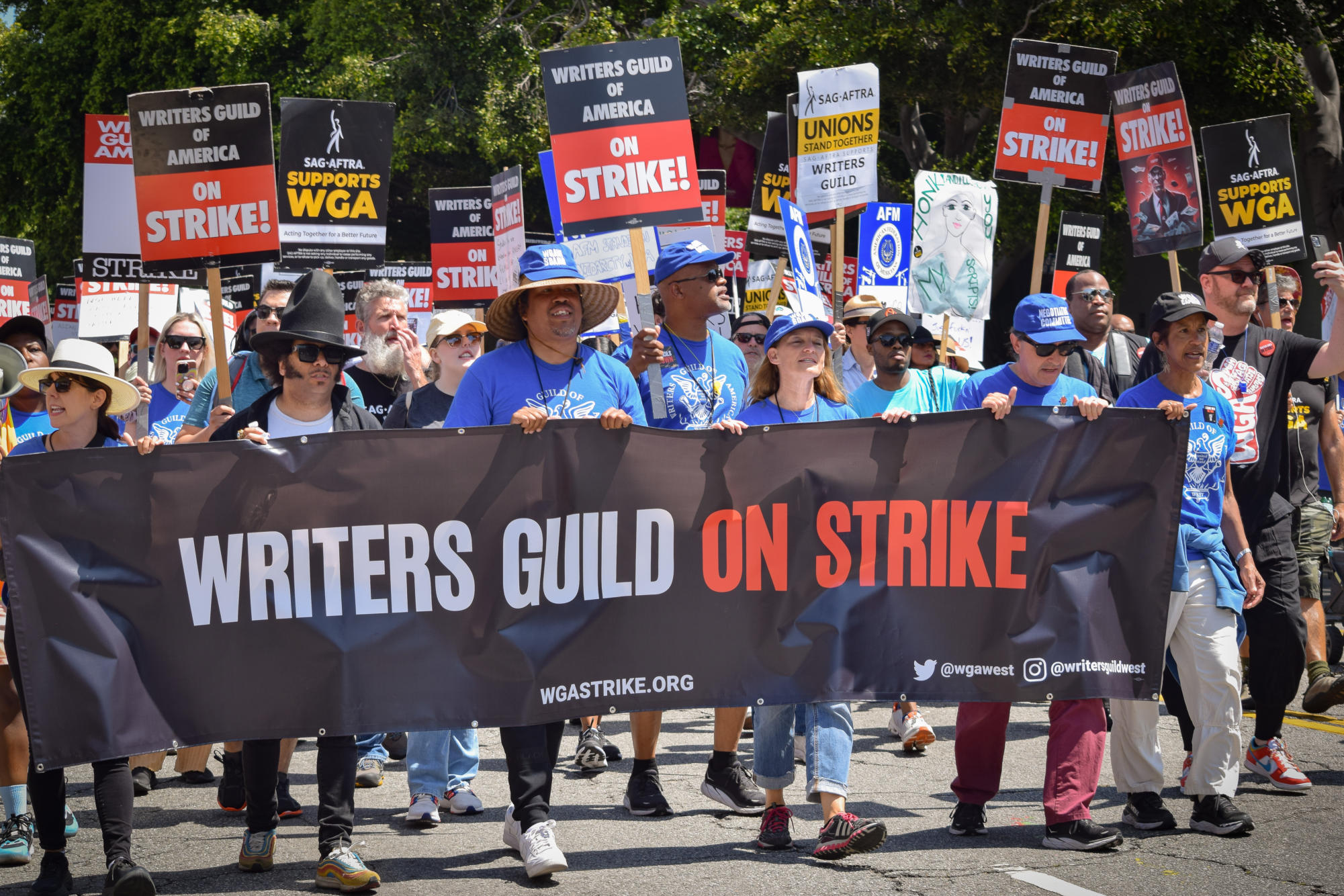 Writers take the streets to protest. These protests are causing disruption in Hollywood.
