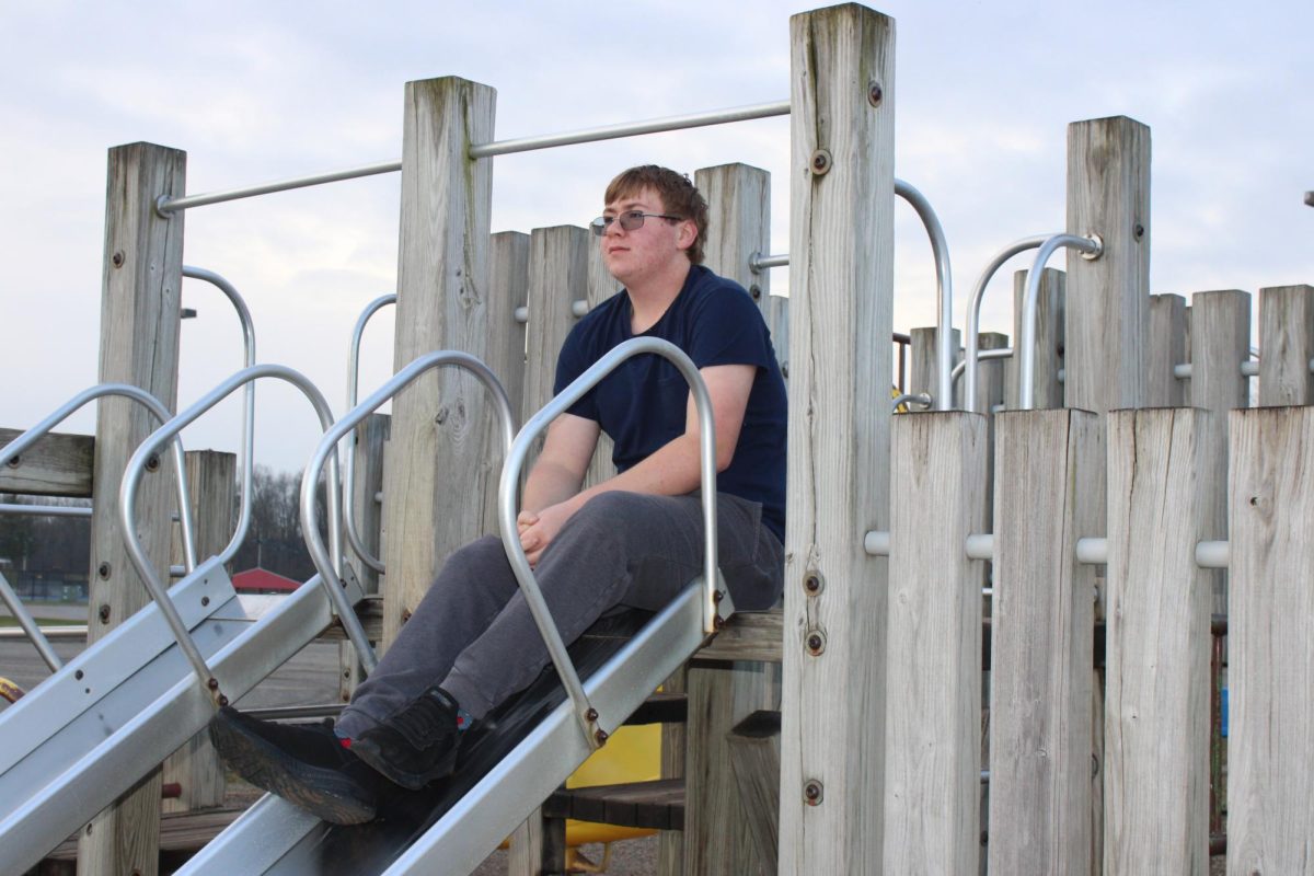 Sitting on the slide of the Landis Elementary School, high school senior Benjamin Atkinson reflects on a simpler time.   