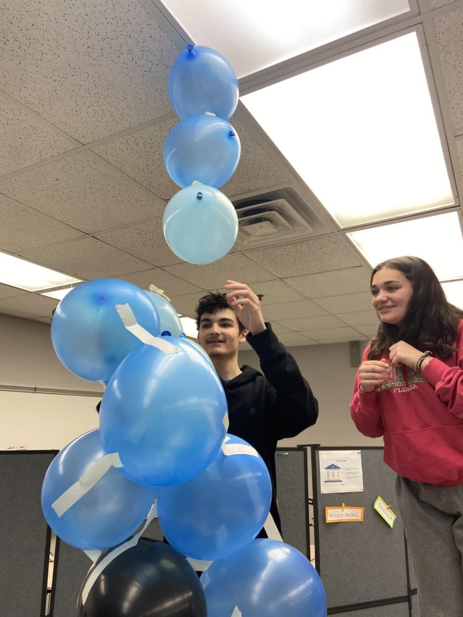 Trying to keep it stable, freshmen Isaiah Hayden and Tiara Lincoln build a tower as high as they can with nothing but balloons, masking tape, and a yardstick.