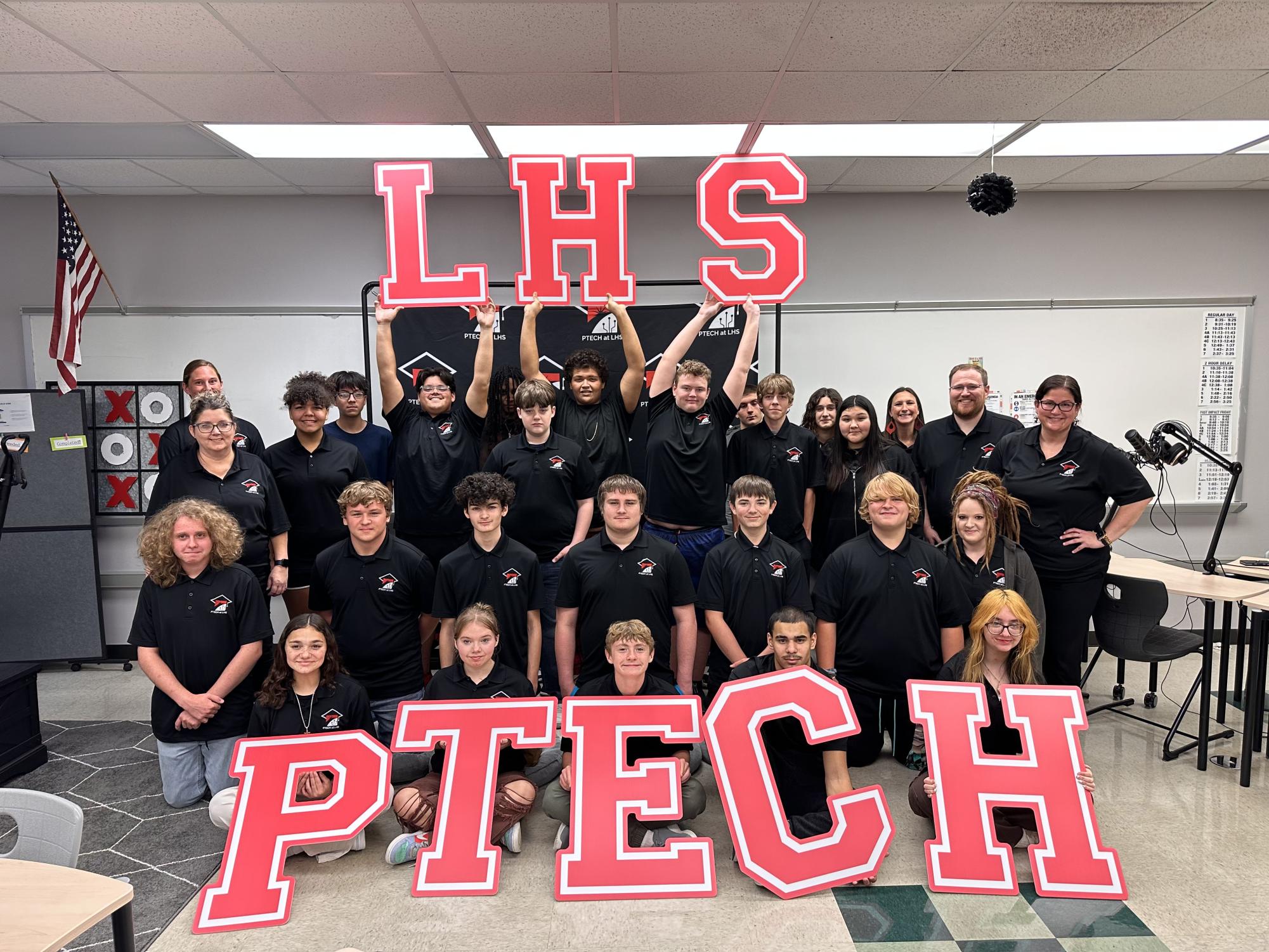 The full P-TECH class of students pose for a picture in their matching polos. Students wear these polos when representing P-TECH in professional settings.