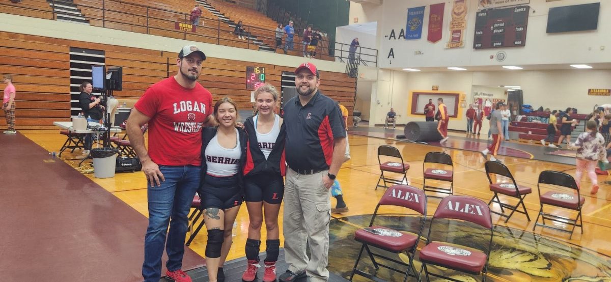 After a meet, senior Marcy Zagal and sophomore Olivia Gibson pose with coaches Sam Fry and Josh Gibson. 