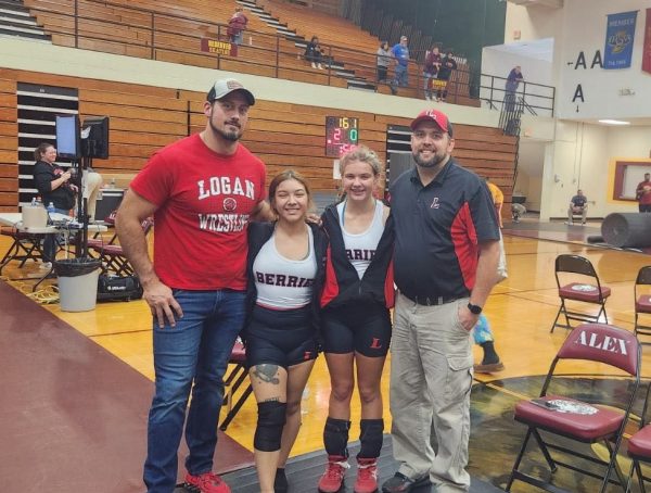 After a meet, senior Marcy Zagal and sophomore Olivia Gibson pose with coaches Sam Fry and Josh Gibson. 