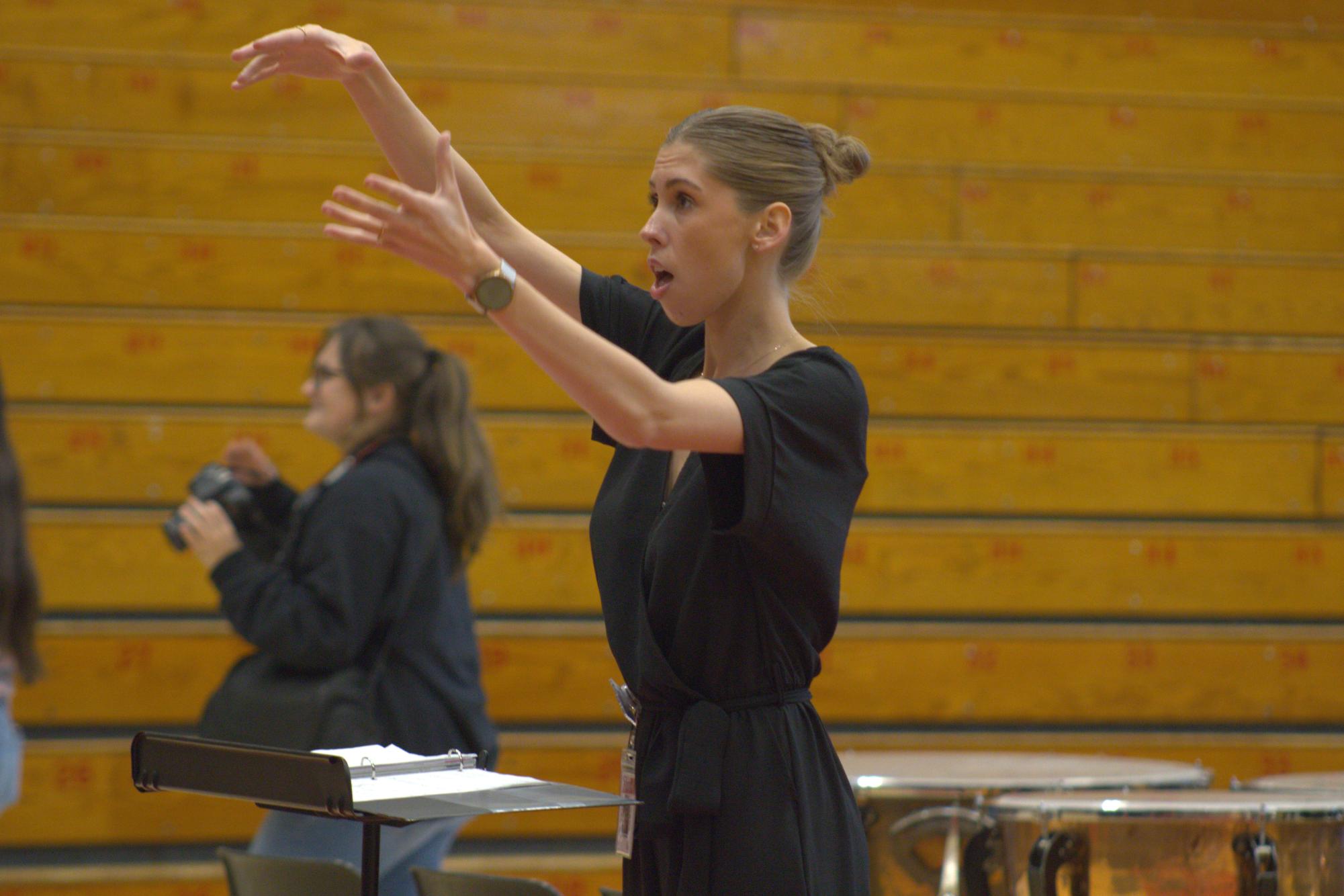 Conducting during the Veterans Day program, choir teacher Emily Brooke keeps the choir on pace during their song.