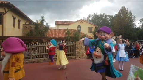 The characters from Disneys Snow White dance around Disney Land.