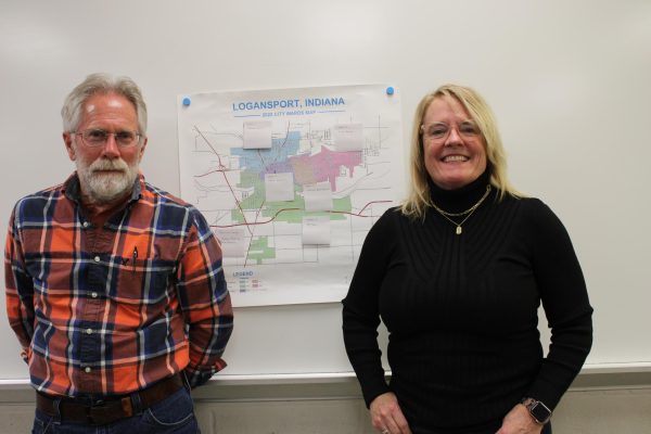 Dave Morris and Suzy Wamsley stand in front of a poster showing where each ward is in Logansport.