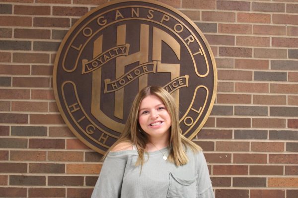 Freshman Samatha Baker poses in front of the school seal.