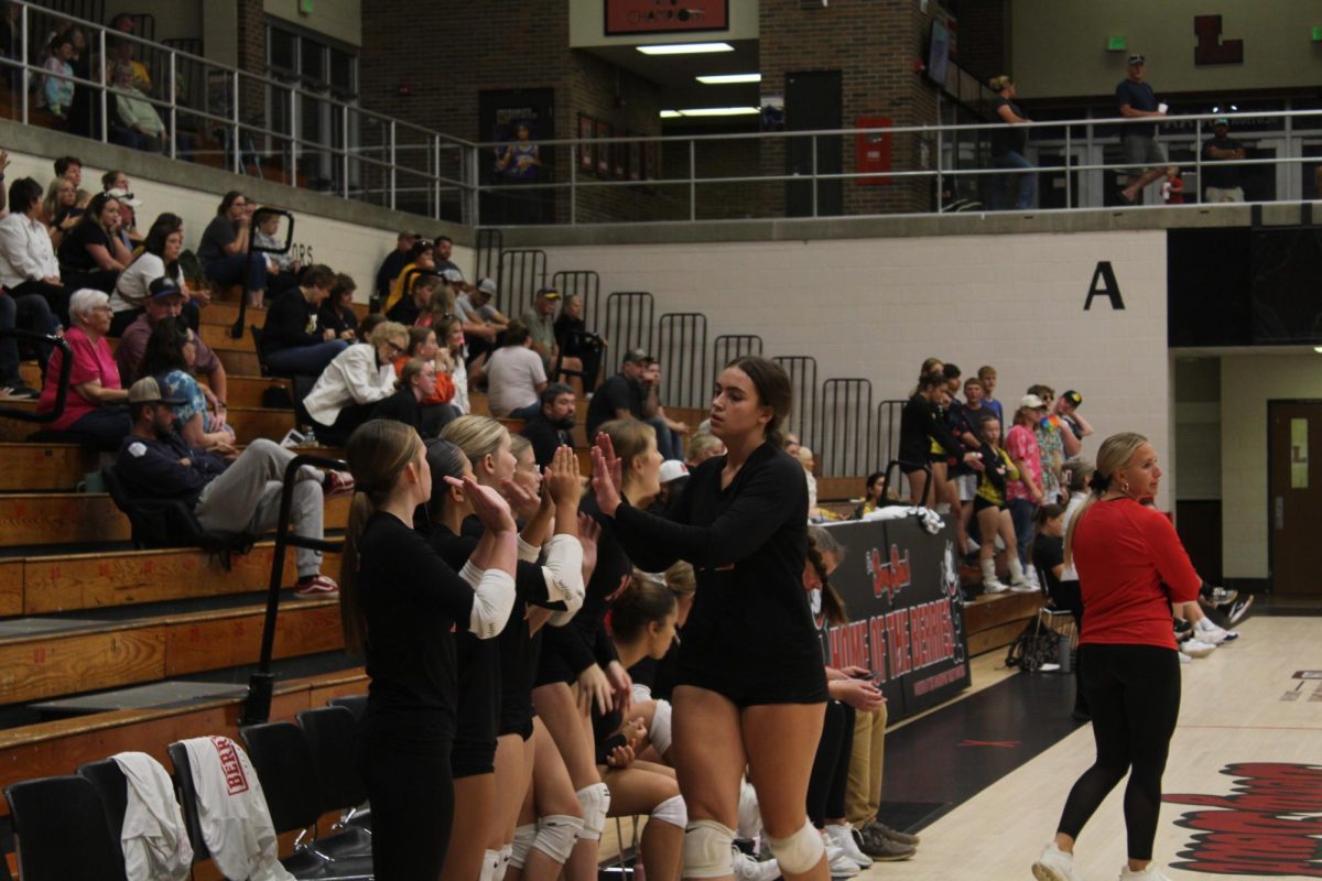 Freshman Varsity volleyball player Khloe Wells high-fives her teammates. Right before this, she made a play for the ball at the game on Sept. 3. 