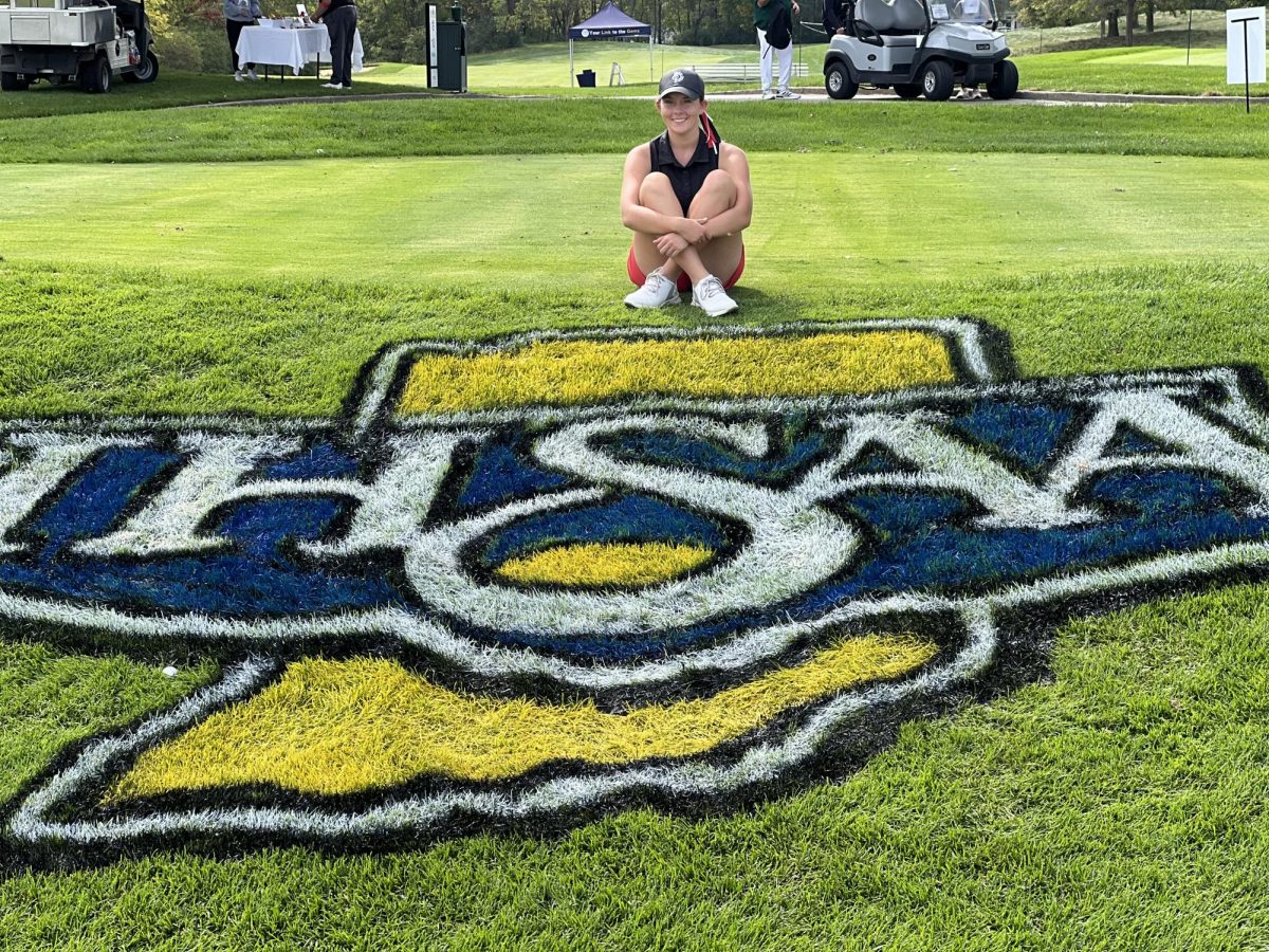 Sophia Kay sits behind the IHSAA Logo at Prairie View Golf Club in Carmel. 