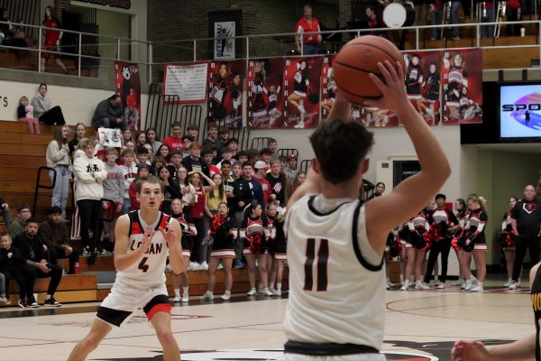 Senior Cayden Walker pivots and raises his arms before finding Carson Dubes at the top of the key.