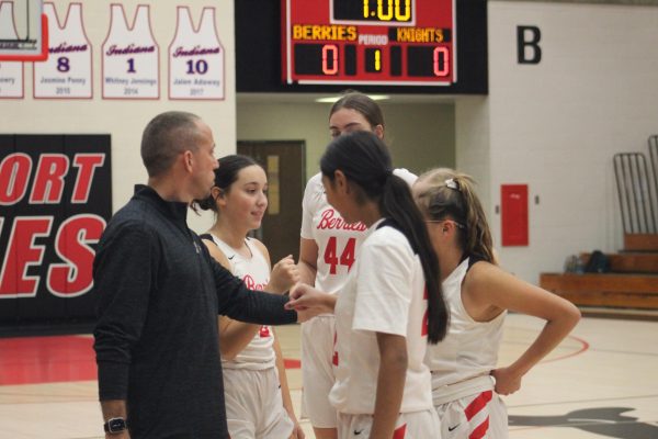 Right before the Junior Varsity game, Coach Michael Richie helps freshmen Khloe Wells and Jazmine Quinones, along with other juniors, with the game plan. (Courtesy of Yearbook)