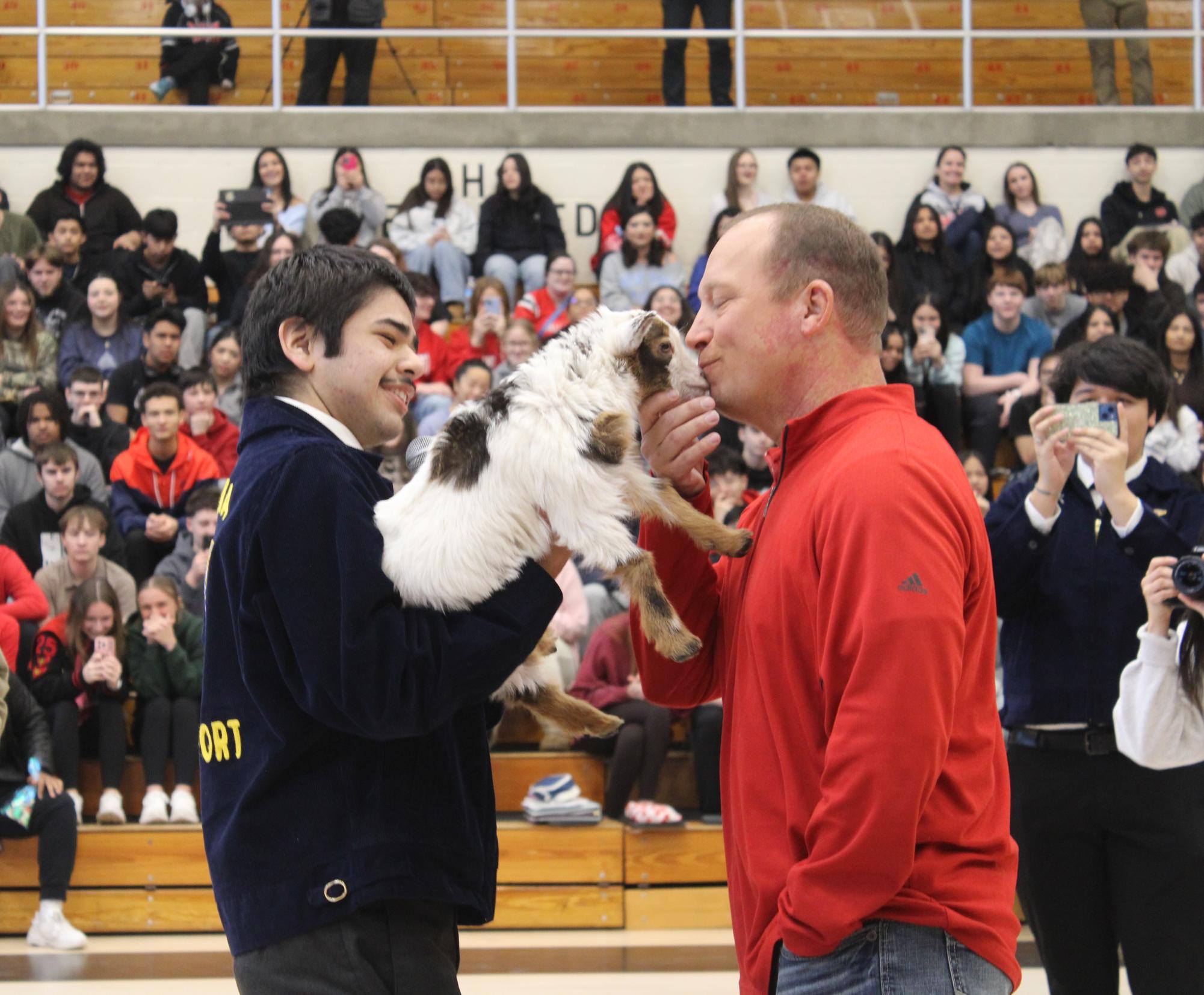 Rick Bair kissing one of the baby goats at the Kiss the Pig event