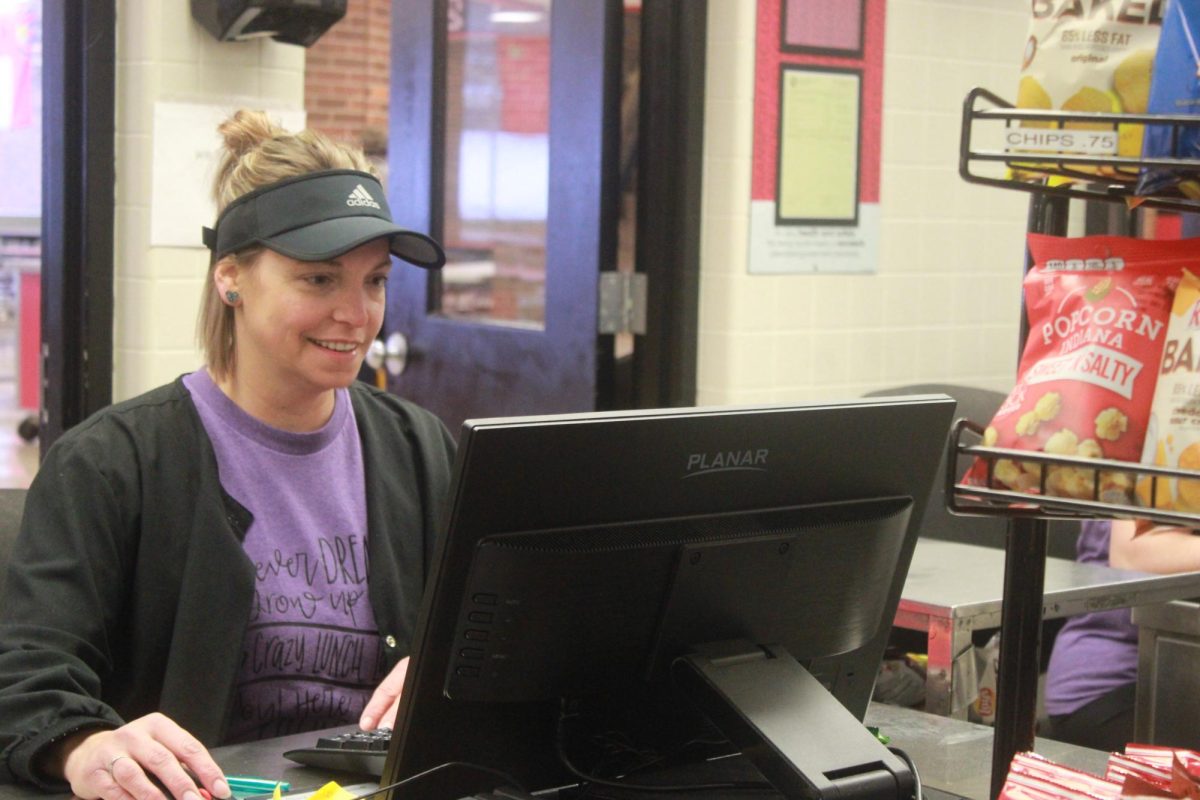 Lunch Lady Becka Wooten is sitting down waiting for students to buy lunch. 