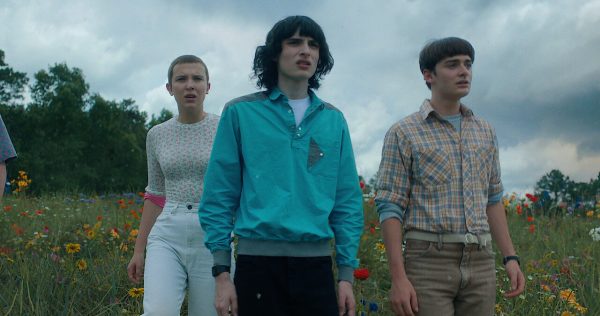 Eleven, Mike Wheeler, and Will Byers look  out to the sky as the Upside Down begins to invade Hawkins.