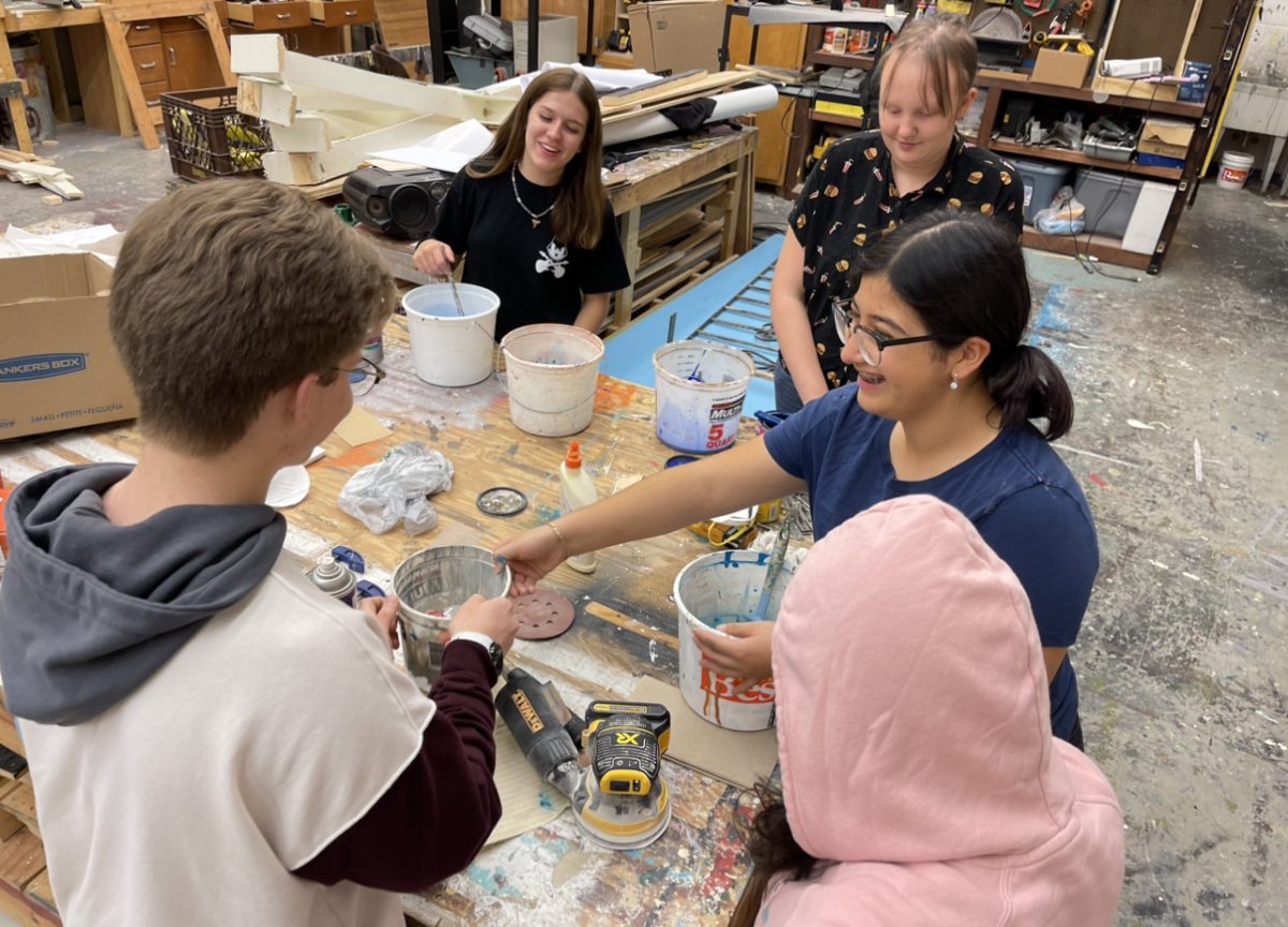 Various members of Tech Crew gather around to paint props for Mamma Mia!