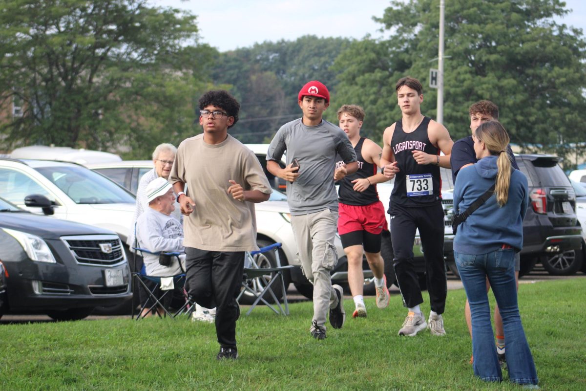 Seniors Jairo Murillo, Ronald Sevilla and Grady Alexander along with junior Eli Schurter participate in a pre race warm-up before the boys varsity race.
