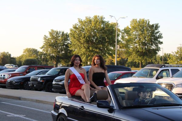 Escorted by senior Layla Lawhead and representing Art Club, senior Gianna Williamson smiles at the crowd.