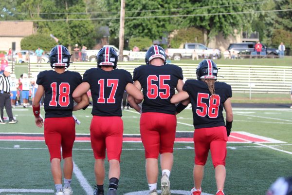 Preparing to meet the opponents and flip the coin before the game seniors Bryson Herr, Loran Taylor, Micheal Berry, and Larry Umholtz walk on the field arm in arm.