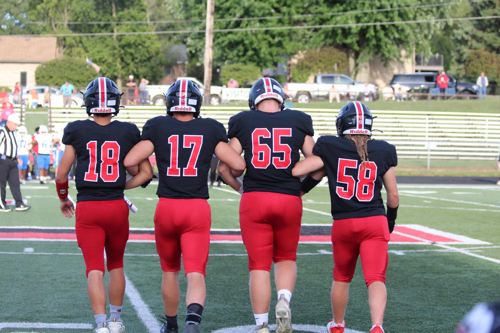 Preparing to meet the opponents and flip the coin before the game seniors Bryson Herr, Loran Taylor, Micheal Berry, and Larry Umholtz walk on the field arm in arm.