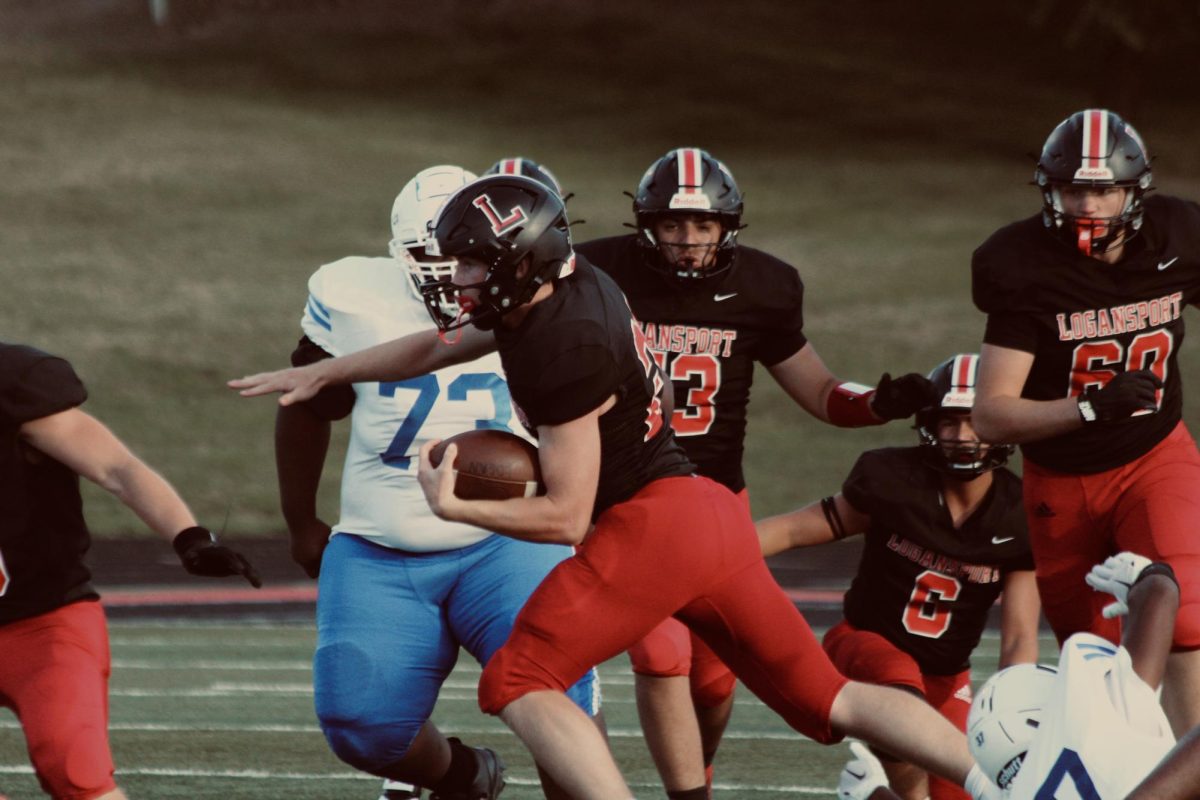 Running back Elliot Baldini carries the ball past defenders against the South Bend Adams Eagles. The Berries went on to defeat the Eagles 54-6.