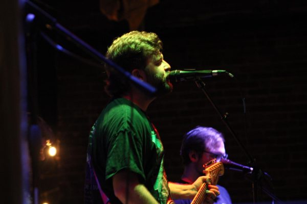 Lead singer of the band "Sell Out Boy" sings into his microphone during an Emo Night performance at Bonus Pints. 