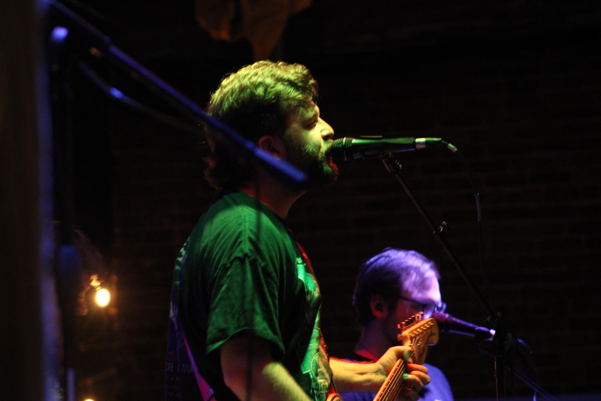Lead singer of the band "Sell Out Boy" sings into his microphone during an Emo Night performance at Bonus Pints.